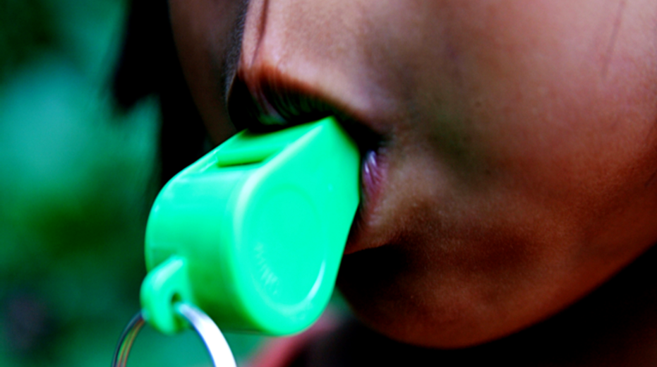 A green whistle being blown